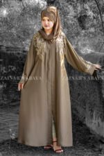 Front Open Abaya in Nida Korean Fabric featuring elegant embroidery on front sleeves cuffs and motif on the scarf. This abaya is in Skin Color