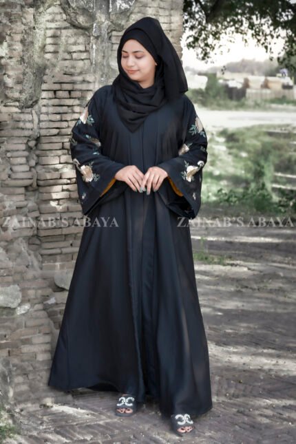 Front Open Abaya in Black Color which is crafted with premium Nida Korean fabric featuring the embroidery on sleeves and backside as well as a matching scarf in chiffon fabric.