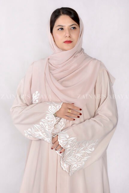 Front Open Abaya in Peach Color crafted with Nida Korean Fabric featuring the stylish embroidery all around bottom sleeves and motif on the scarf which is in chiffon fabric and same color.