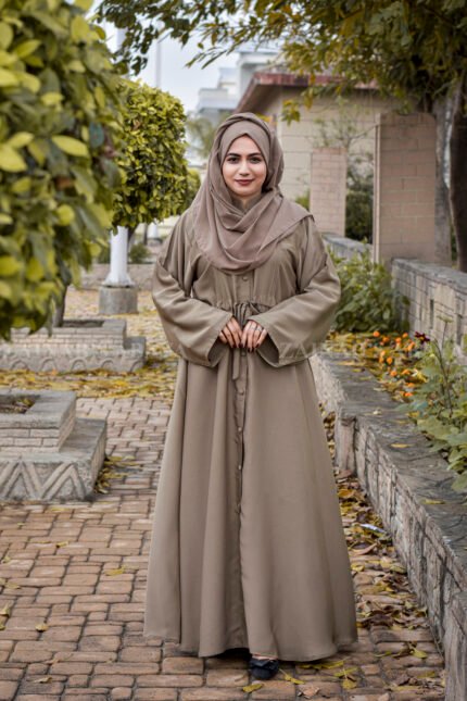 Front Open Abaya in Skin Color which is crafted in premium nida korean fabric featuring the button style on front stretchy elastic and plates style as well as a matching scarf in chiffon fabric.