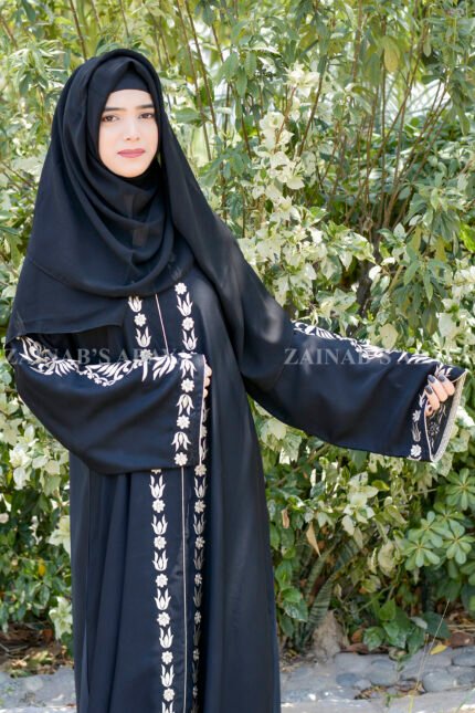 Black Front Open Abaya in Nida Korean Fabric with Embroidery and Piping on Front and Sleeves as well as motives on the scarf in same pattern which is in chiffon fabric.