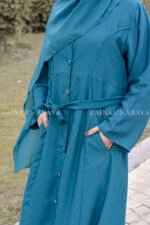 Front Open Abaya which is crafted with Nida Korean Fabric in Zinc Color featuring the elegant button down style, two side pockets, an adjustable belt or a matching scarf in chiffon fabric.