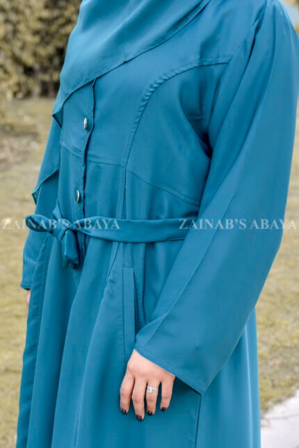 Front Open Abaya in Nida Korean Fabric in Zinc Color featuring button down style, two side pockets, an adjustable belt or a matching scarf in chiffon fabric.