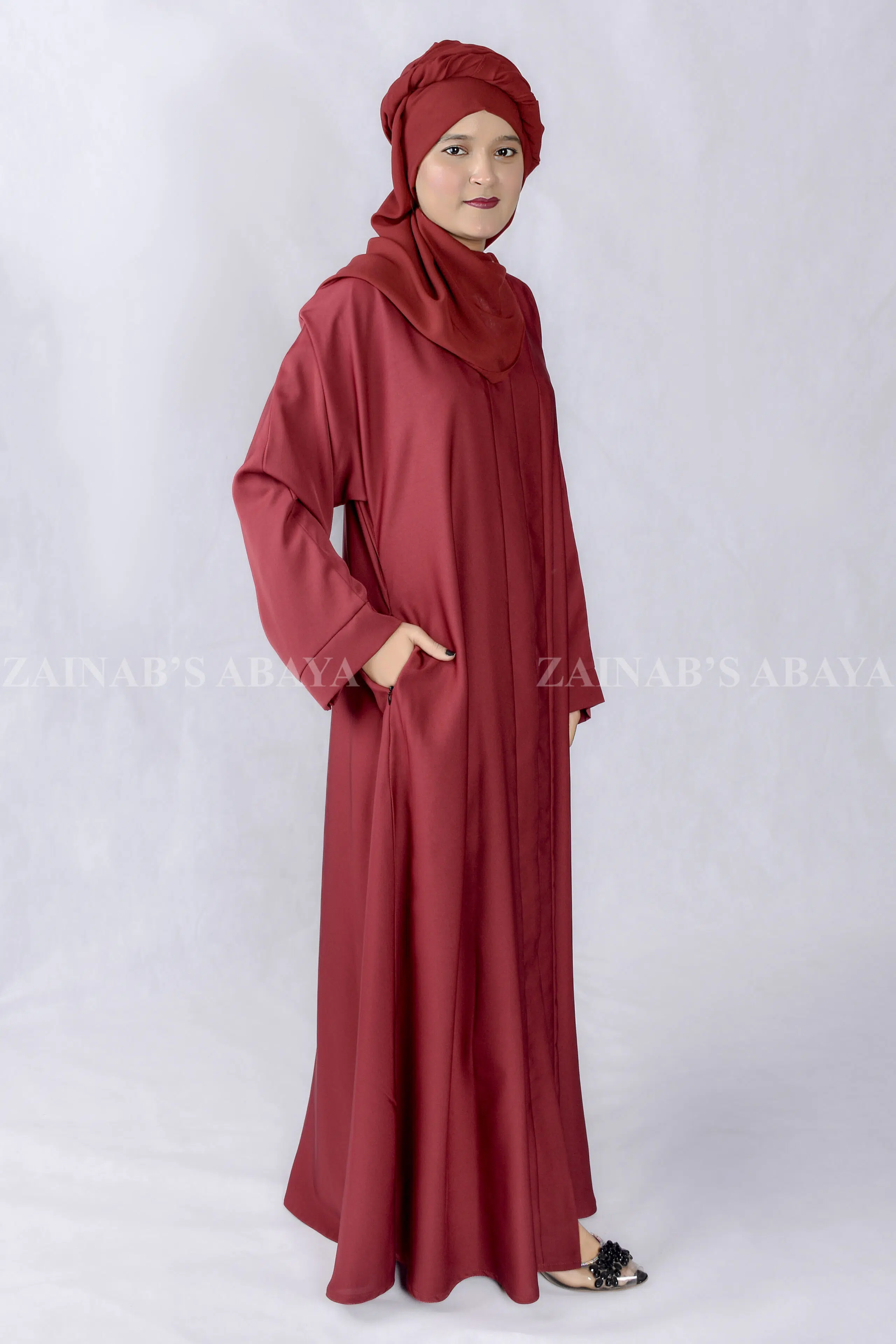 Red Colored Front Open Abaya in Nida Korean Fabric with left right side pockets as well as a matching scarf in Chiffon Fabric.