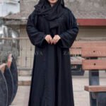 Black Maxi Abaya in Nida Korean Fabric featuring the strips and pearl work on front and sleeves as well as on scarf which is in chiffon fabric.