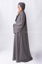 Grey Colored Gown Abaya in Nida Korean Fabric featuring embroidery and cutwork on front borders and sleeves as well as same matching scarf in chiffon.