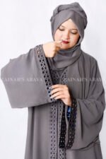 Grey Colored Gown Abaya in Nida Korean Fabric featuring embroidery and cutwork on front borders and sleeves as well as same matching scarf in chiffon.