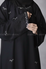 Black Maxi Abaya for women in Pakistan crafted with Premium Nida Korea Fabric featuring the bow style embroidery and stone work.