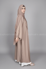 Nida Coat Style Abaya for women in Pakistan with button style on front and sleeves as well as a matching scarf in chiffon fabric.