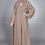 Nida Coat Style Abaya for women in Pakistan with Button Style on Front and Sleeves as well as a matching scarf in chiffon fabric.